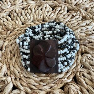 Multi-strand glass bead handmade bracelet with monkey pod plumeria closure